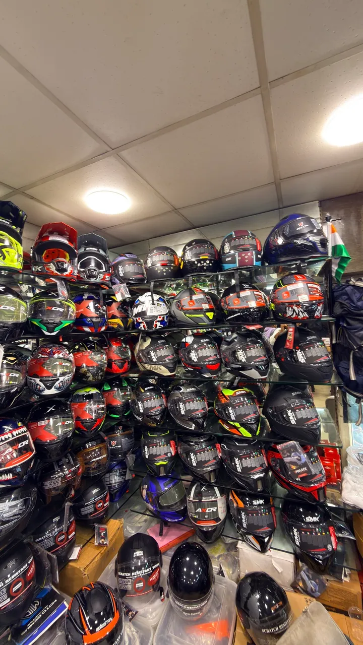 Wall of open-face helmets at Speed World