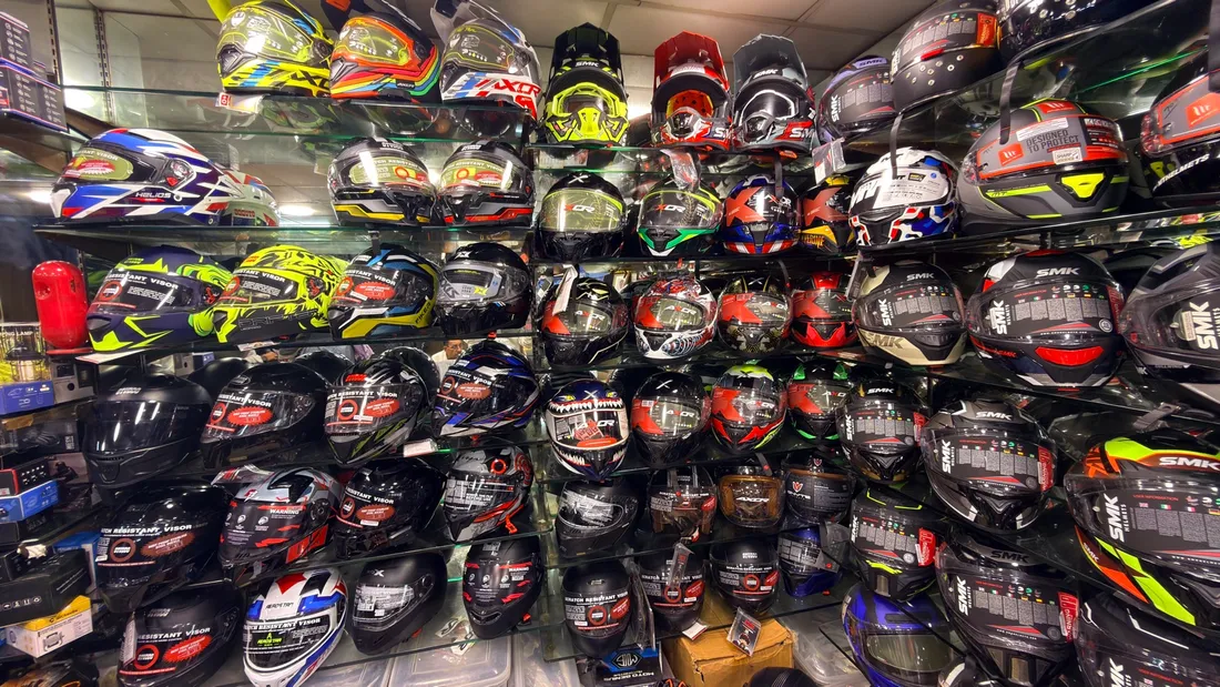 A full wall of motorcycle helmets in every colour at Speed World, Karol Bagh