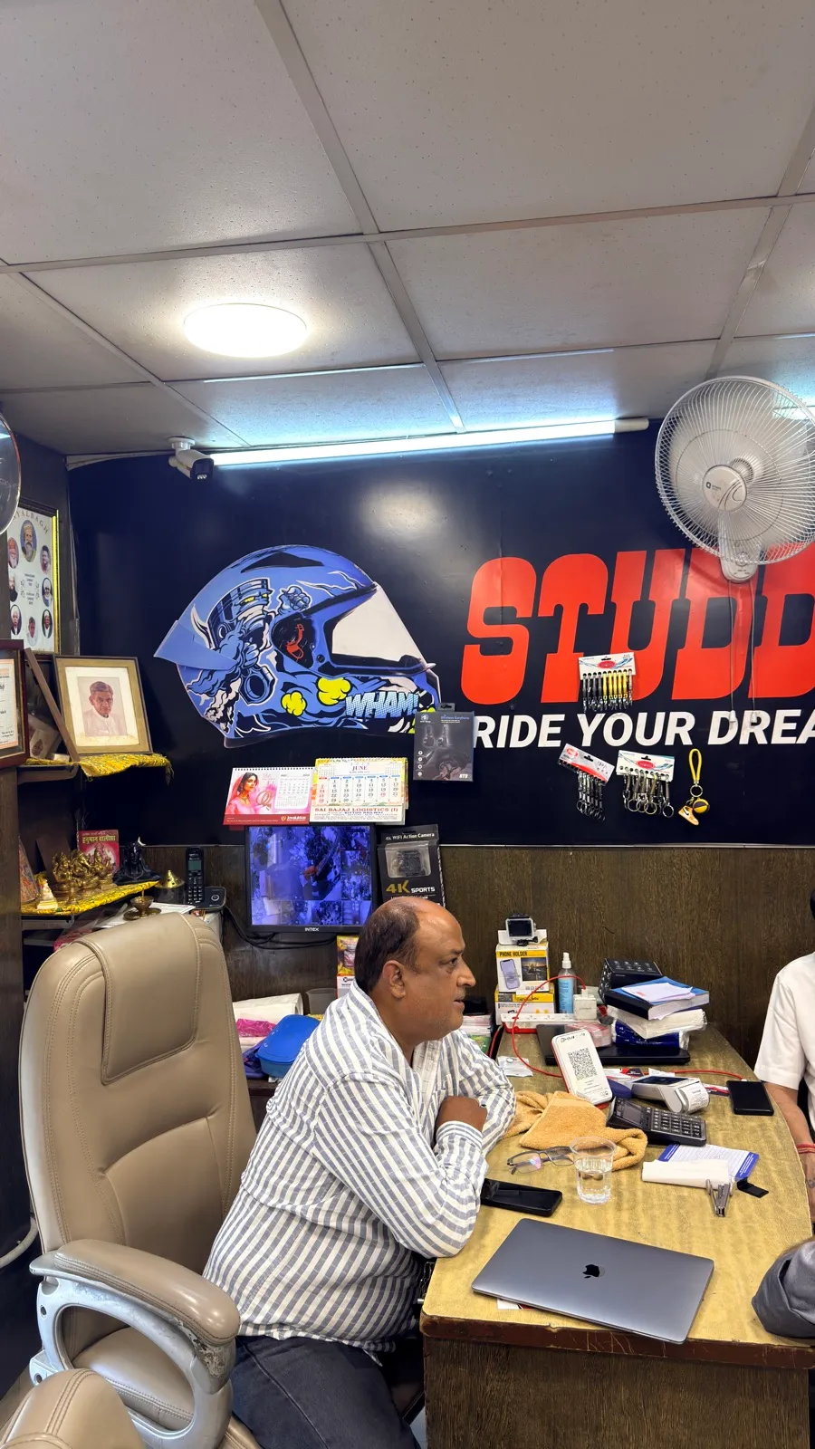 The owner of Speed World at his desk beneath the Studds 'Ride Your Dreams' banner