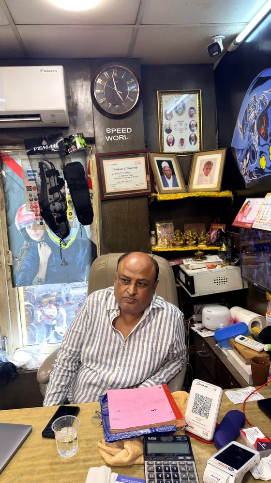 The owner at his desk under the Speed World sign