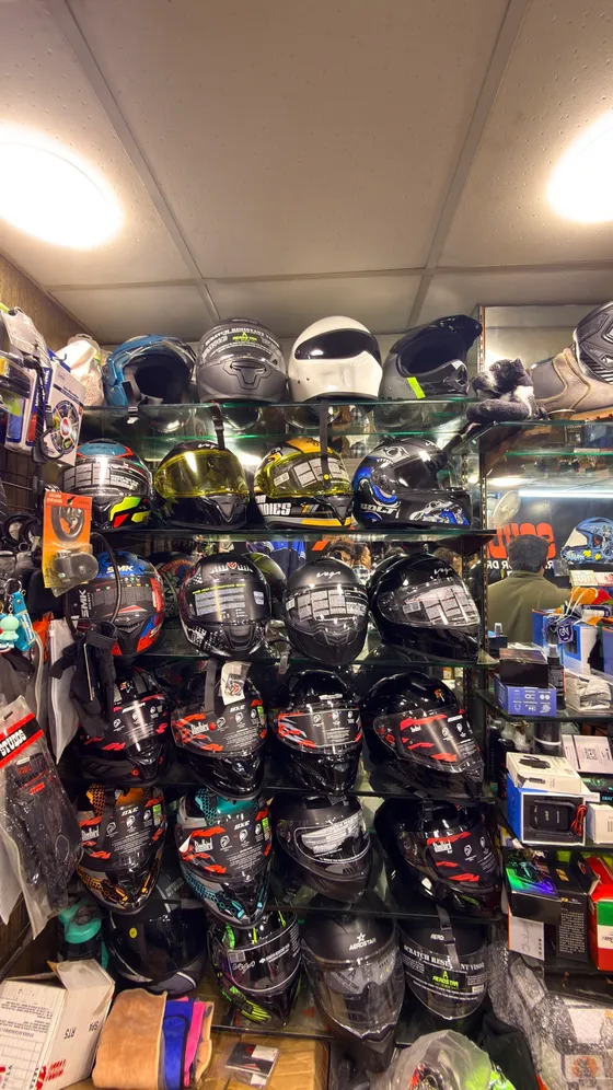 Flip-up and full-face helmets lining the shelves