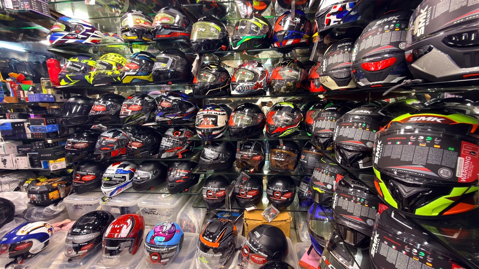 A dense wall of SMK and other full-face helmets at Speed World